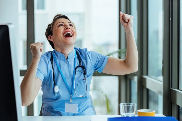 Cheerful female doctor celebrating good news while working in the hospital.